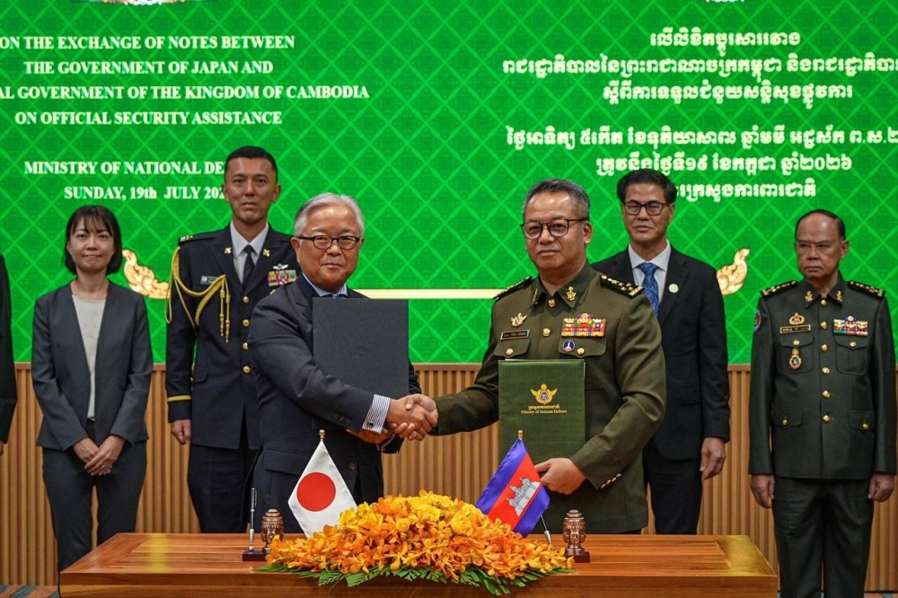 Ambassador Ueno shaking hands with H.E. General TEA Seiha, Deputy Prime Minister and Minister of National Defence, holding the exchanged notes