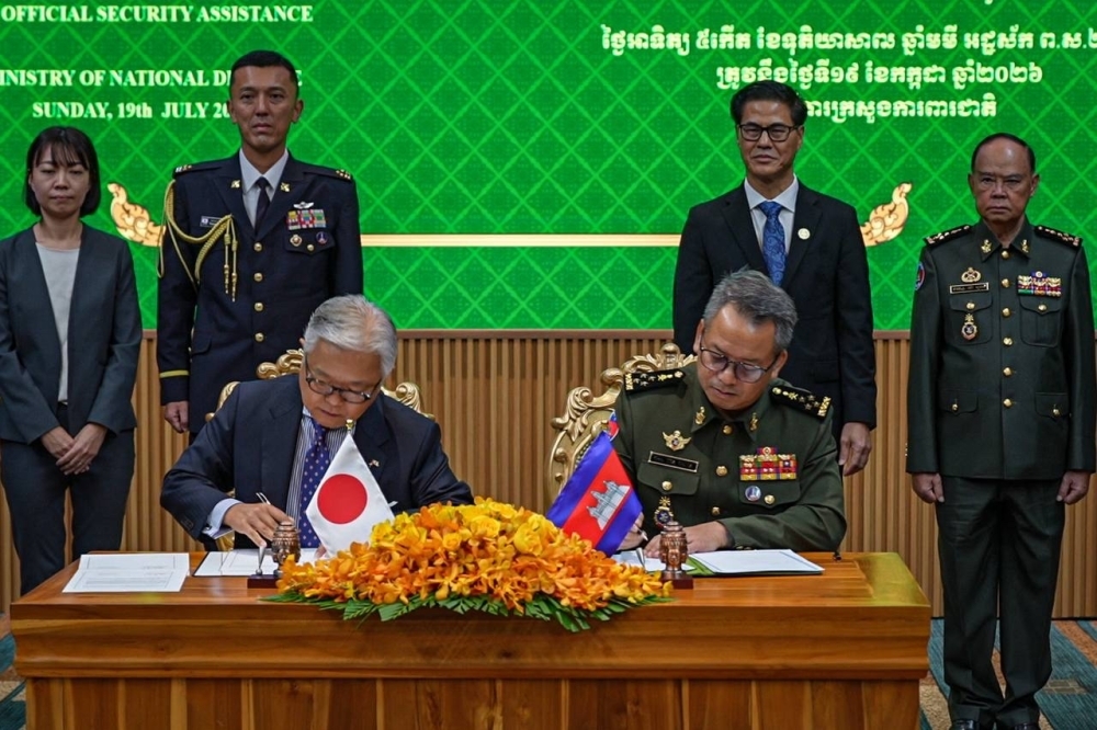 Ambassador Ueno and H.E. General TEA Seiha, Deputy Prime Minister and Minister of National Defence signing the exchanged notes