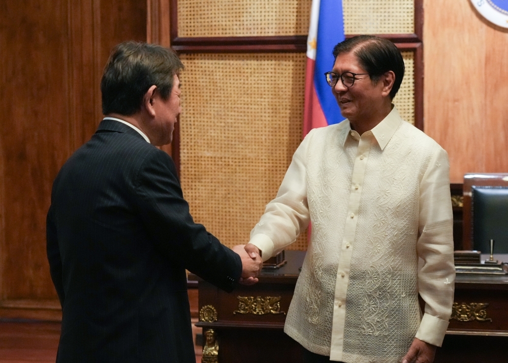 Foreign Minister MOTEGI shaking hands with President Marcos