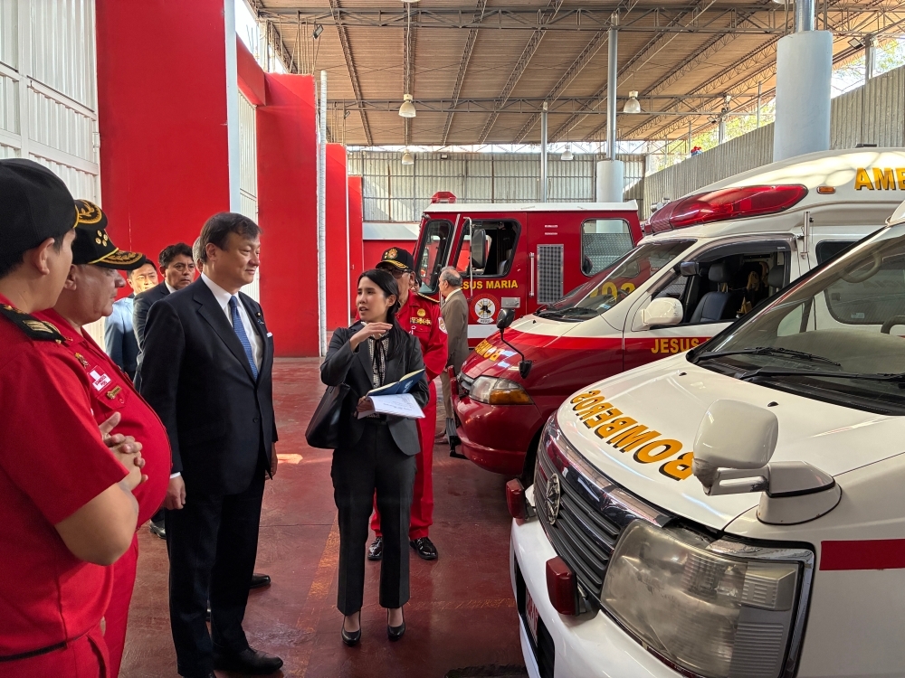 State Minister HORII receiving an explanation from fire brigade personnel while watching the ambulances