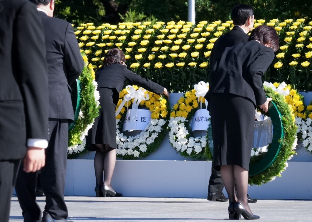 State Minister KUNIMITSU offering flowers at the ceremony