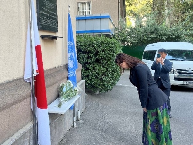 Parliamentary Vice-Minister ERI bowing after laying flowers in front of the memorial plate