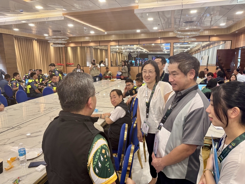 Parliamentary Vice-Minister ONISHI having a brief chat with election management committee officials