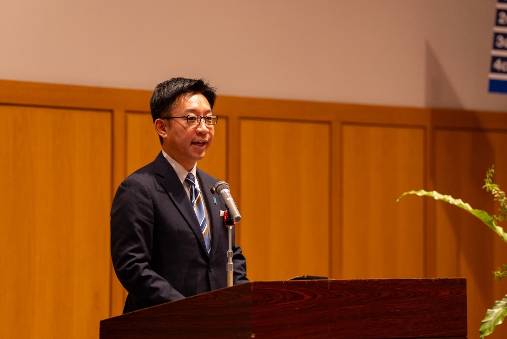 Deputy Chief Cabinet Secretary NAKANISHI reading aloud the congratulatory message from Prime Minister TAKAICHI