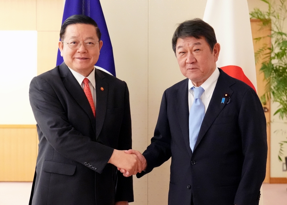 Minister MOTEGI shaking hands with Secretary-General Kao Kim Hourn