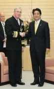 握手を交わし記念写真を撮る安倍晋三内閣総理大臣とミラー米中央海軍司令官