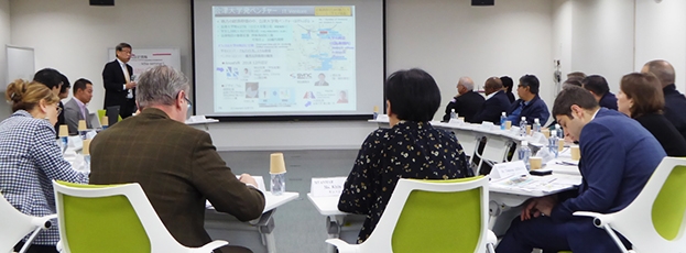 (写真3)大学理事のプレゼンテーションにメモをとりつつ質問する大使たち