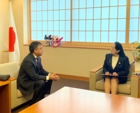 着席し、意見交換を行う、尾身政務官とグスマン党首の様子