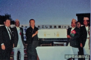 (写真2)平成8年利賀・ツクチェ村おこし交流展 in ネパール (左から3人目:宮崎道正・利賀村長(当時))