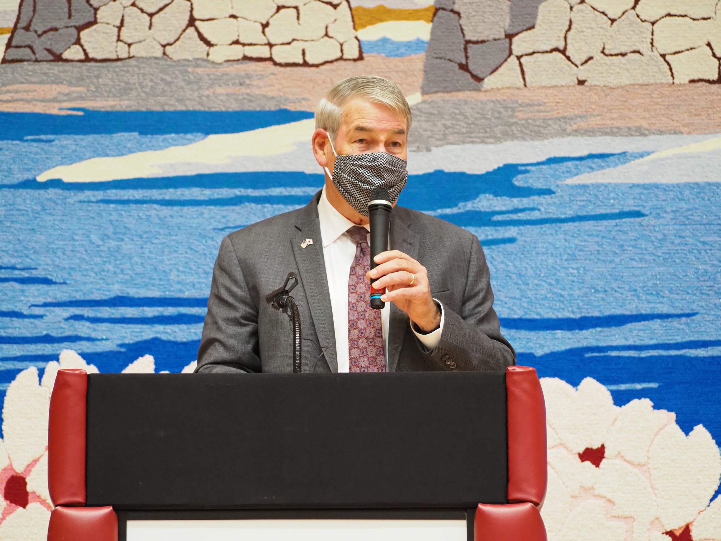 演壇に立ち、開会式で挨拶する、ブレイディ理事長の様子
