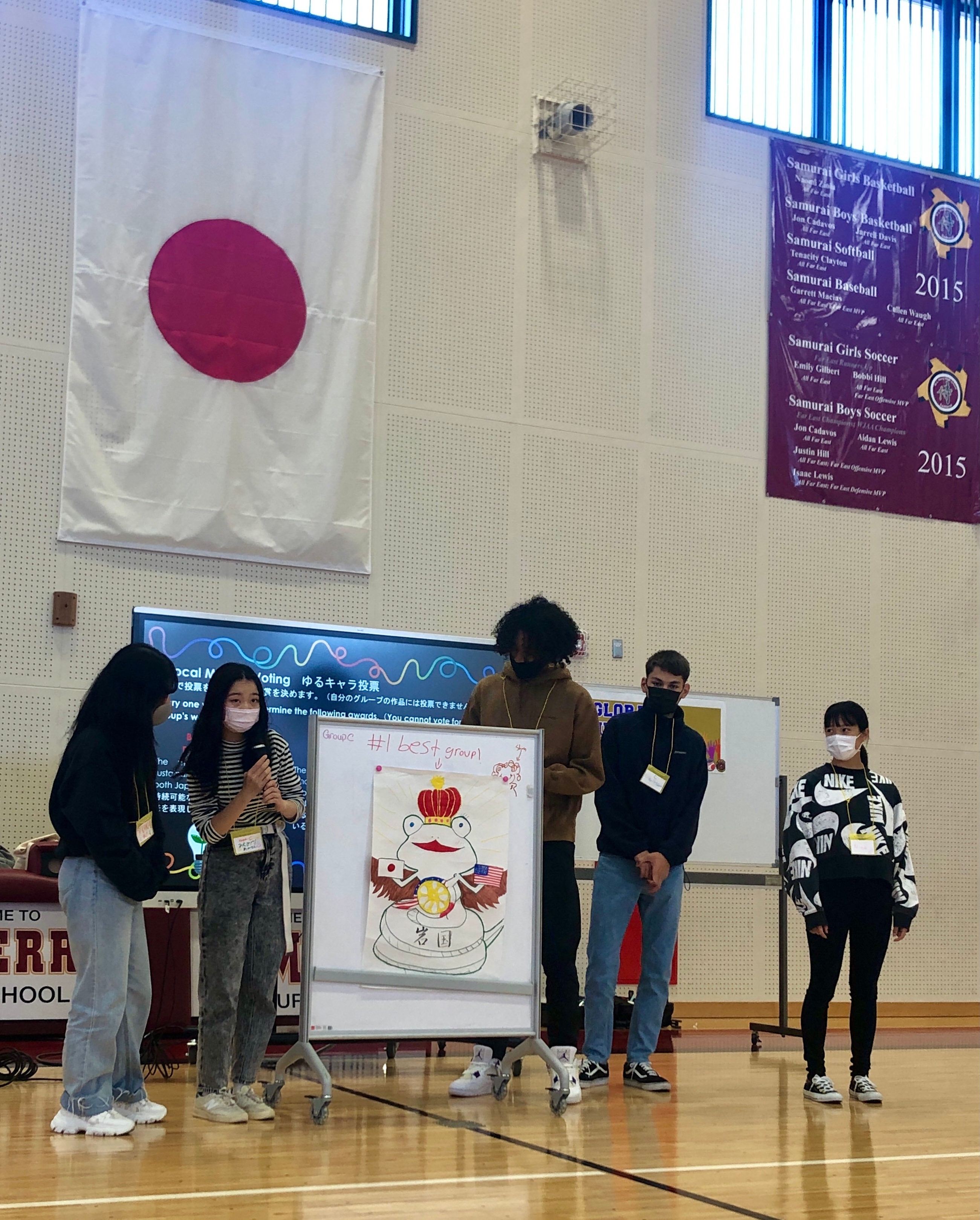 ホワイトボードを用いてプレゼンテーションを行う、日米5名の学生達の様子