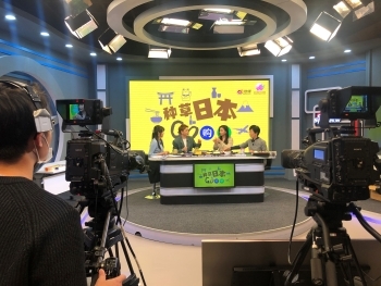 (写真)種草日本Go購够と書かれたモニター画面と出演者たち