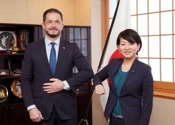 正面を向き、レフスキ駐日ポーランド共和国大使と肘タッチを交わす、鈴木外務副大臣の様子