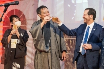 (写真1)ヘルツォグ大統領(右)と着物姿の水嶋大使(中央)