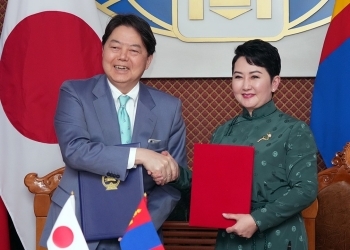 署名を終え、握手しながら記念撮影に応じる日モンゴル両外相の様子