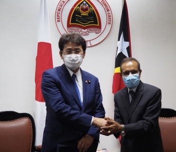 ルアク東ティモール首相と握手をしながら記念撮影に応じる三宅総理特使