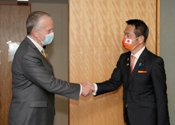 向かい合い、握手を交わす、小田原外務副大臣とサリバン米国連邦上院議員の様子