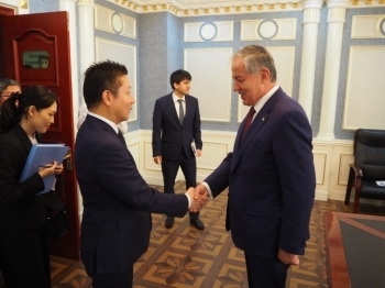 互いに向かい合い、握手を交わす、本田政務官とムフリッディン外務大臣の様子