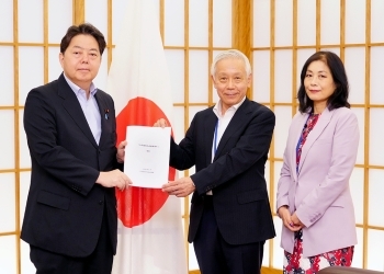 正面を向き提言書を掲げる、林大臣と松本顧問、および正面を向き記念撮影に応じる、小谷顧問の様子