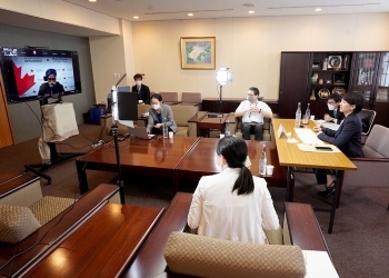 鈴木副大臣と、サージャン・カナダ国際開発大臣とのテレビ会談が行われている会議室の様子