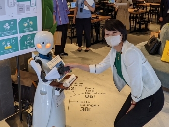 分身ロボット「OriHime」を介した遠隔での接客サービスを体験する、鈴木副大臣の様子
