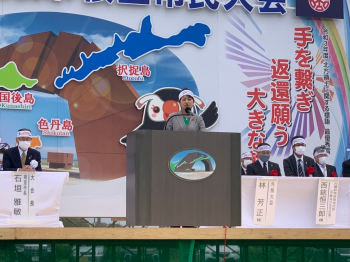 北方領土返還要求根室市民大会に出席し、外務大臣の挨拶を代読する、鈴木外務副大臣の様子