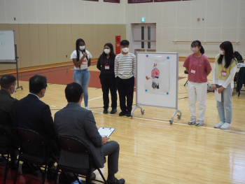 オリジナルのご当地キャラクターに関するプレゼンテーションを行う、日米の学生たちの様子