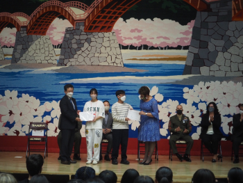 受領した修了証を手に持ち、記念撮影に応じる、日米の学生代表