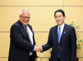正面を向き、笑顔で握手を交わす、岸田総理大臣とホフマンスキ所長の様子