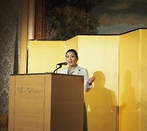 演台に立ち、ゼスチャーを交えてスピーチする、吉川政務官の様子
