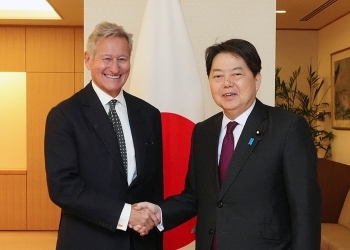 正面を向き、笑顔で握手をかわす、林大臣とチップマン所長の様子