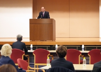 登壇し、スピーチを行う、髙木政務官の様子