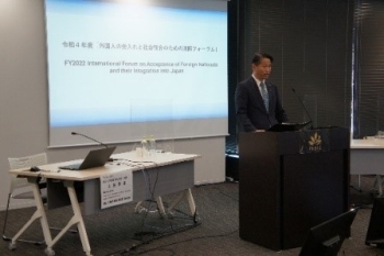演台に立ち、開会挨拶を行う、山田副大臣の様子