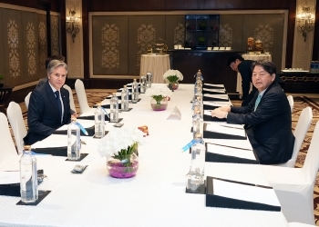 テーブルにつき、会談直前に写真撮影に応じる、両外相の様子