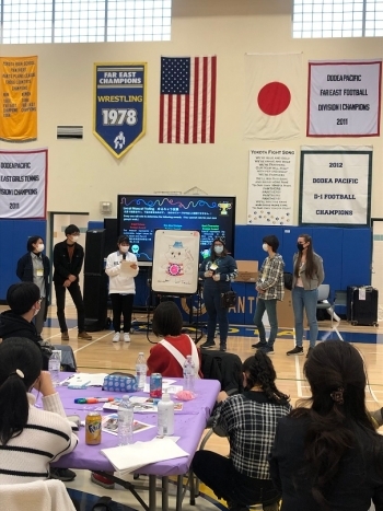 ホワイトボードを用い、ご当地キャラクターに関するプレゼンテーションを行う、日米の学生たちの様子