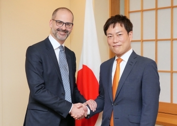 正面を向き、握手を交わす、秋本政務官とギャラガー上級副社長の様子