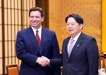 正面を向き、笑顔で握手を交わす、林大臣とデサンティス知事の様子