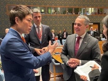 カシス大臣と立ち話を行う、秋本政務官の様子