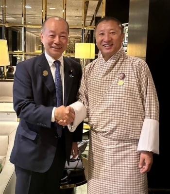 正面を向き、笑顔で握手を交わす、高木政務官とドルジ外務貿易大臣の様子