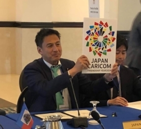 ロゴマークを掲げる武井外務副大臣の様子