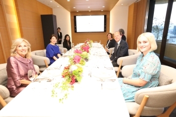 夕食会のテーブルにつき、笑顔で写真撮影に応じる、G7首脳配偶者の様子