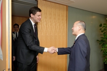 向かい合い、握手を交わす、髙木政務官とイービー州首相の様子