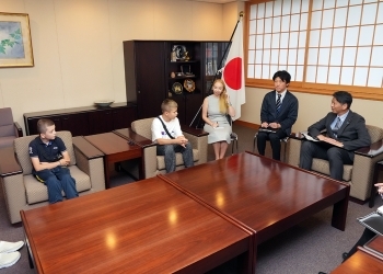着席し、対話を行う、山田副大臣とウクライナ人子供力士2名の様子