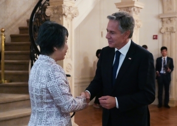 向かい合い、握手を交わしながら会話を行う、両外相の様子