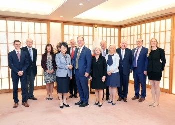 正面を向き、握手を交わす、上川大臣とドーアAEI所長、および、写真撮影に応じる一行の様子