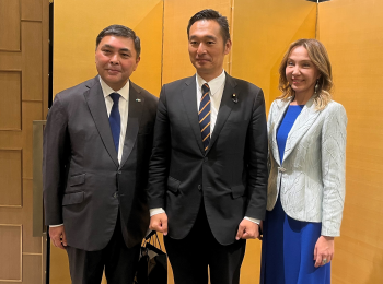 正面を向き、エシムベコフ駐日カザフスタン大使らと共に写真撮影に応じる、深澤政務官の様子