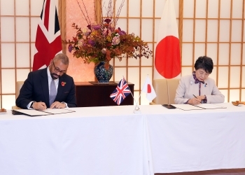 テーブルにつき、覚書に署名を行う、両外相の様子