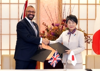 覚書に署名後、正面を向き、握手を交わす、両外相の様子