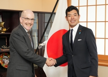 正面を向き、笑顔で握手を交わす、辻󠄀副大臣とズムワルト理事長の様子
