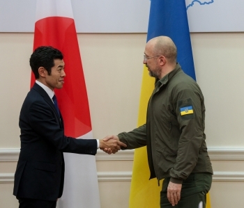 向かい合い、握手を交わす、辻󠄀外務副大臣とシュミハリ首相の様子